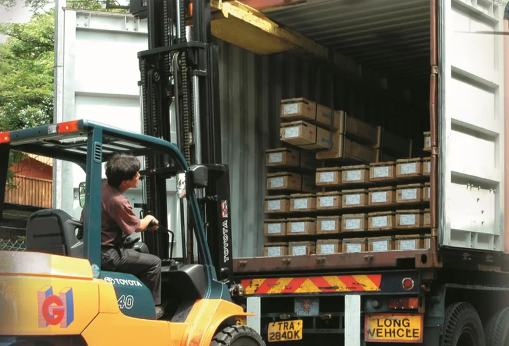 Forklift unloading metal bars from a container at Hua Guan Metal & Engineering