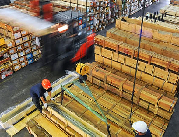 Staff handling metal bars in the Hua Guan warehouse